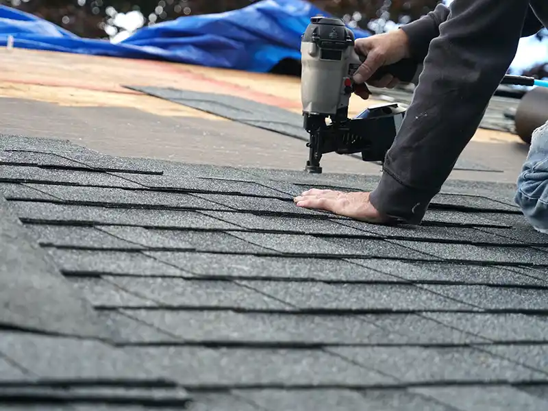 Roofer installing new shingles